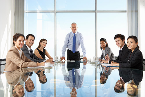 Image of a people sitting and smiling at a meeting room table