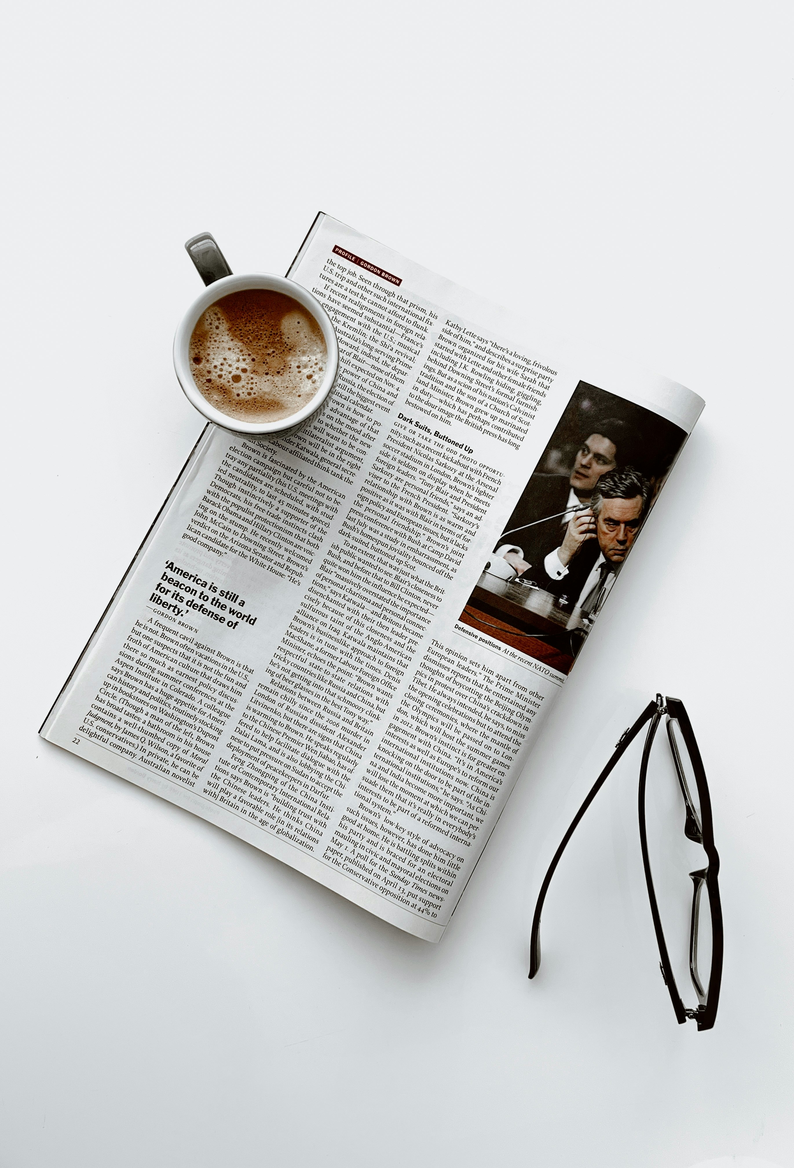 Image of a mug of coffee and glasses on a newspaper